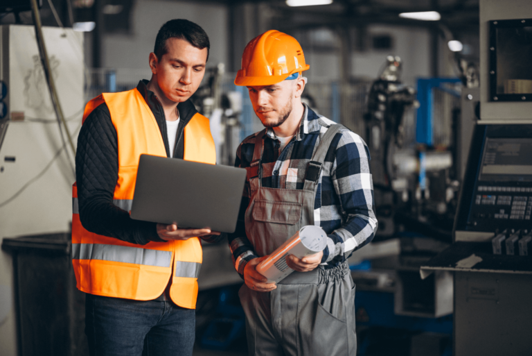 Two business professionals in an office reviewing paperwork to manage employee turnover insurance rates.